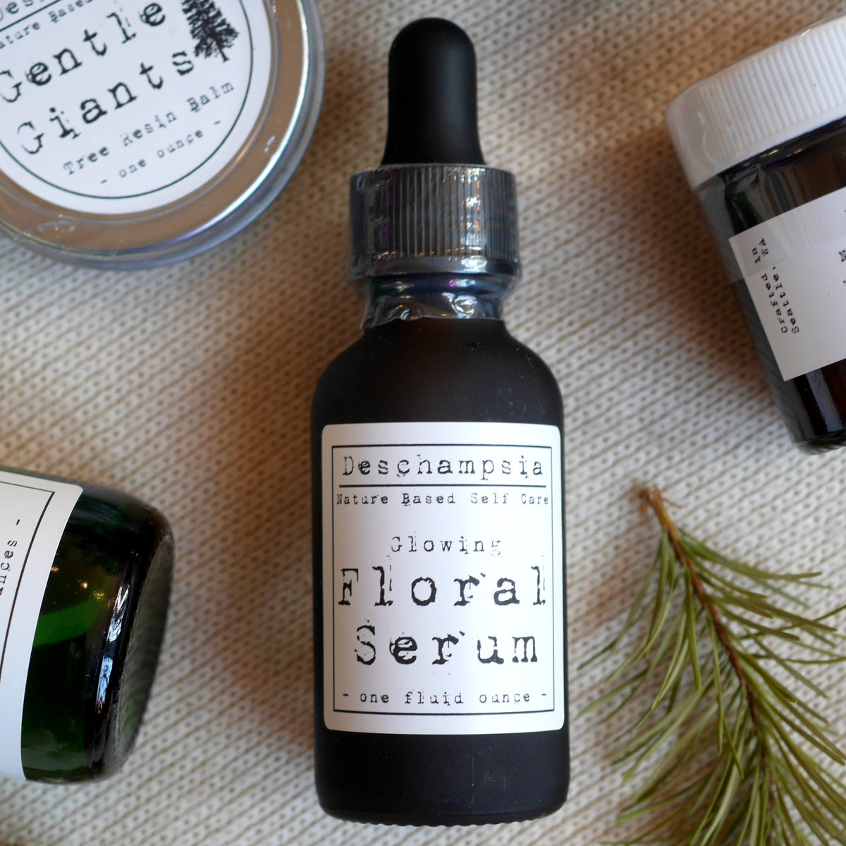 Glowing Floral Serum bottle with botanical materials and other Deschampsia products