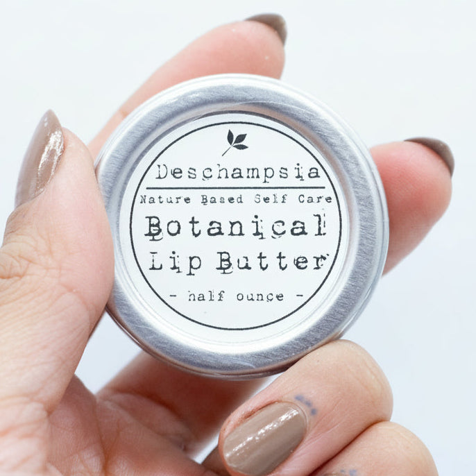Botanical Lip Butter tin held in one hand