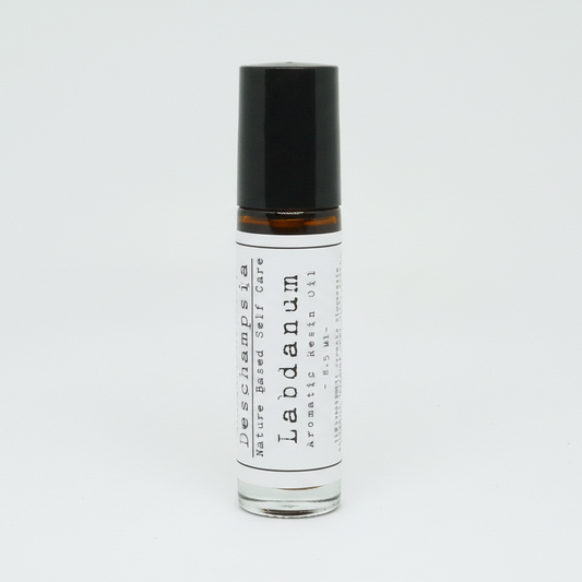 Roll-on bottle of Labdamum perfume oil with black cap on a white background
